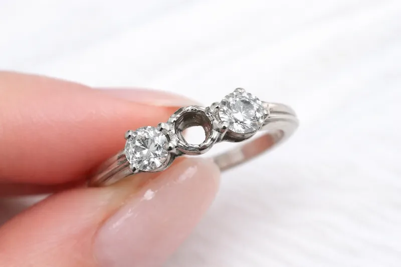 Diamantring med tom fatning der steinen har falt ut